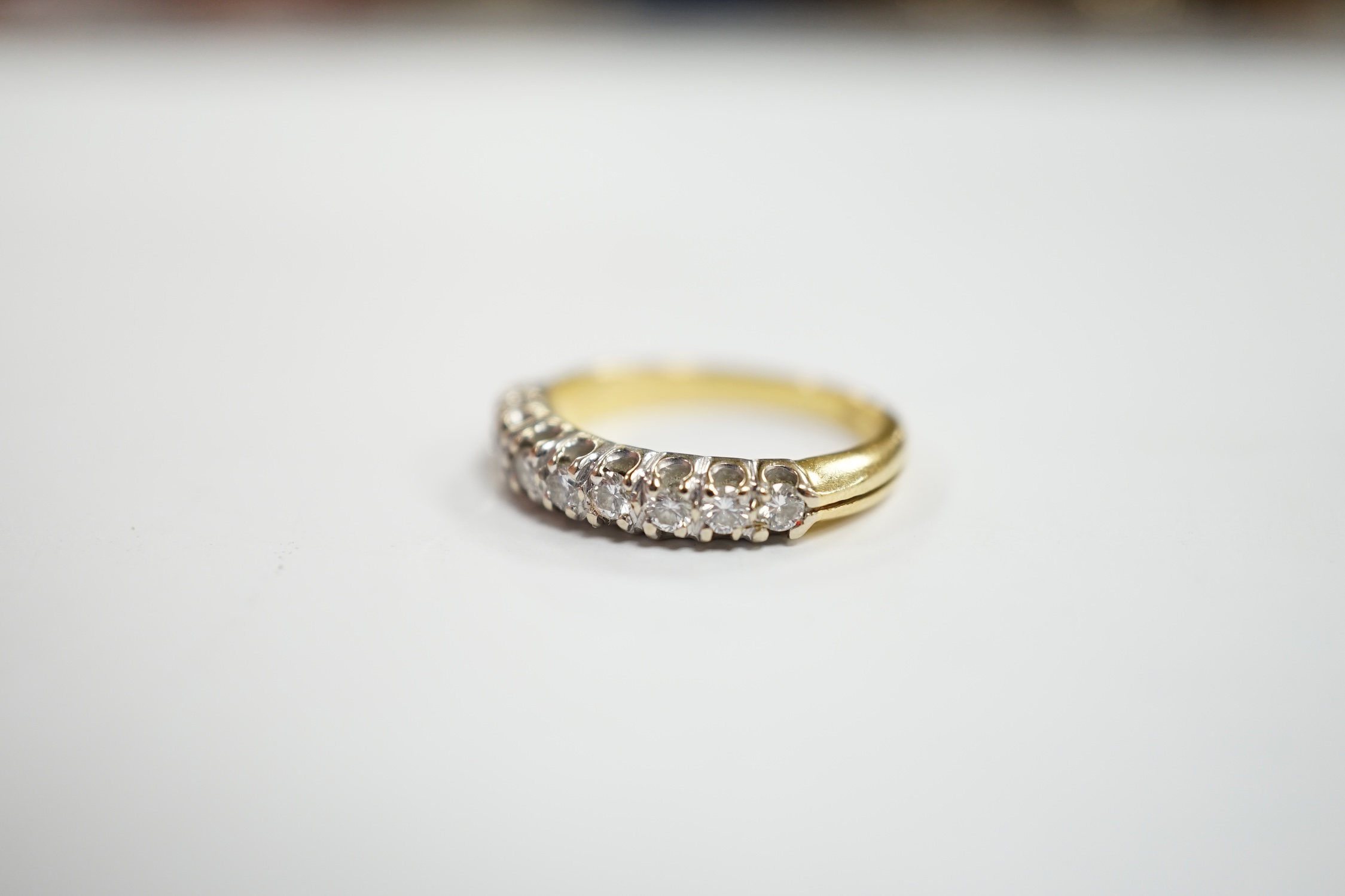 A modern 750 yellow metal and nine stone diamond chip set half hoop ring, size I/J, gross weight 3.1 grams.